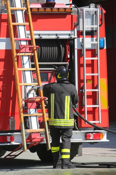 Firefighters in action take the ladder from the fire engine