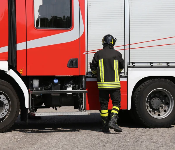 Brave firefighter with fire engine truck on the road