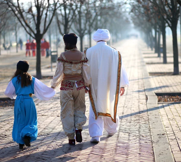 Family with oriental clothes walking in the park