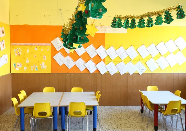 Kindergarten classroom with chairs and table with drawings of ch