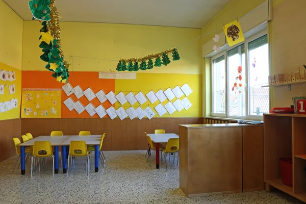 Preschool classroom with chairs and table with drawings of child