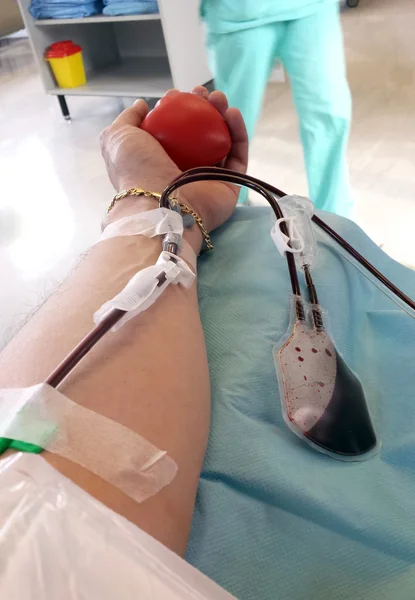 Blood donor during the transfusion at the hospital with the needle