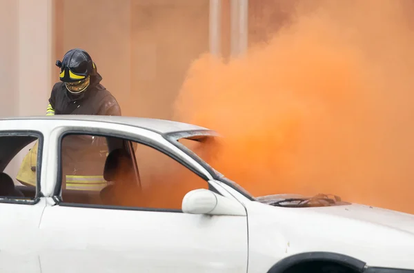 Firemen during exercise to extinguish a fire in a car