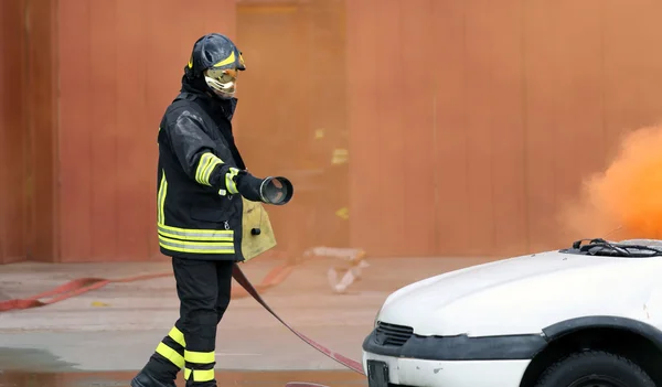 Firefighters during exercise to extinguish a fire in a car