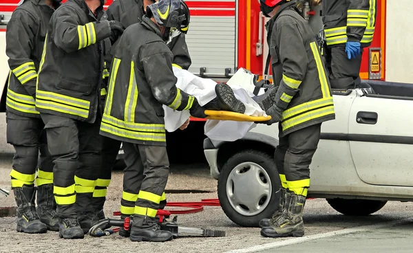 Wounded person carried by firefighters on a stretcher