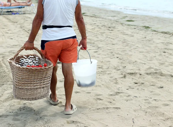 Seller on the beach with fruit skewers made with fresh fruits