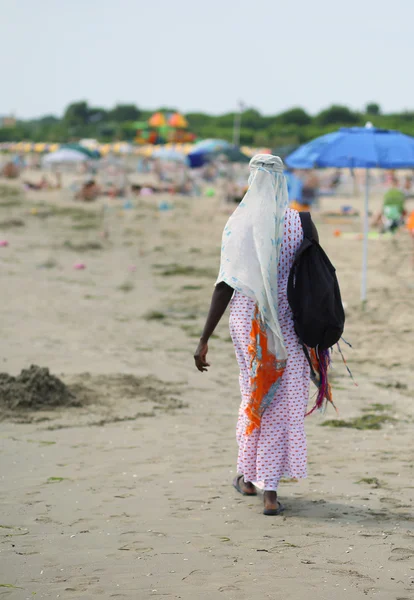 African woman Combs hair with colorful braids on the beach