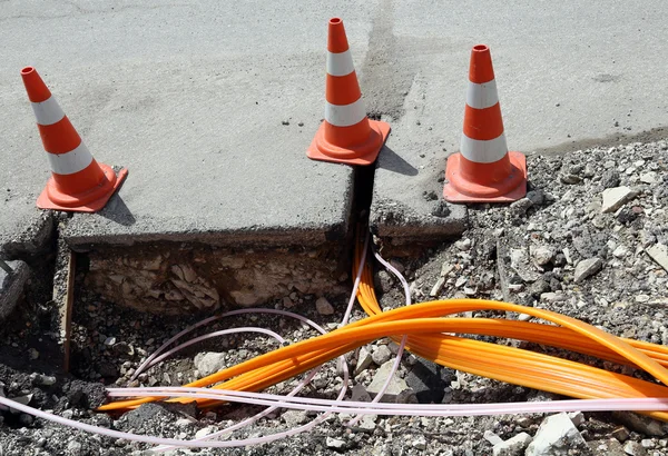 Road construction with pipes for laying optical fiber