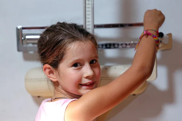 Little girl weighs with an ancient scale