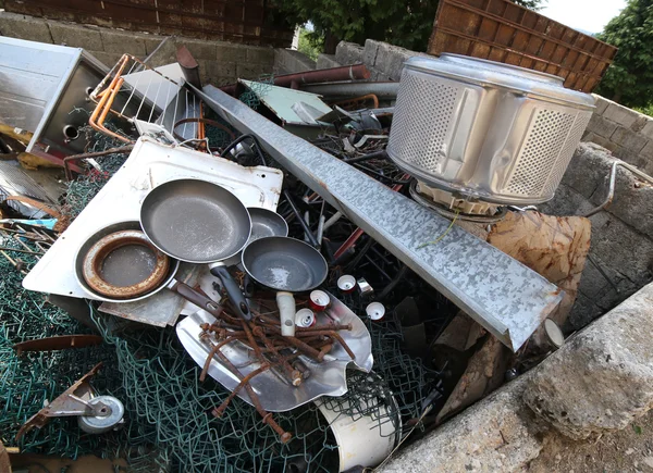 Old pans and washing machine basket and rusty iron ore