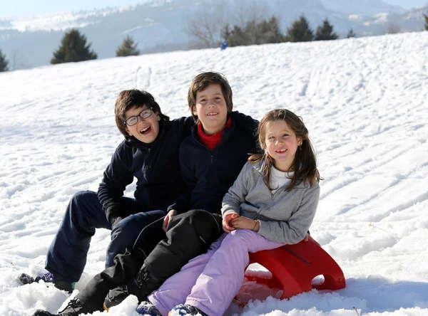 Three happy kids on snow during the summer holidays