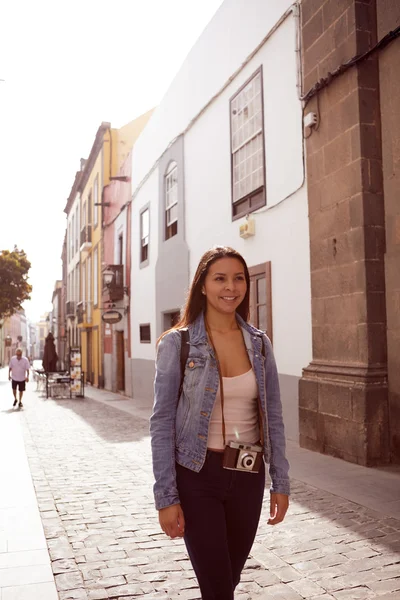 Woman walking in city with camera