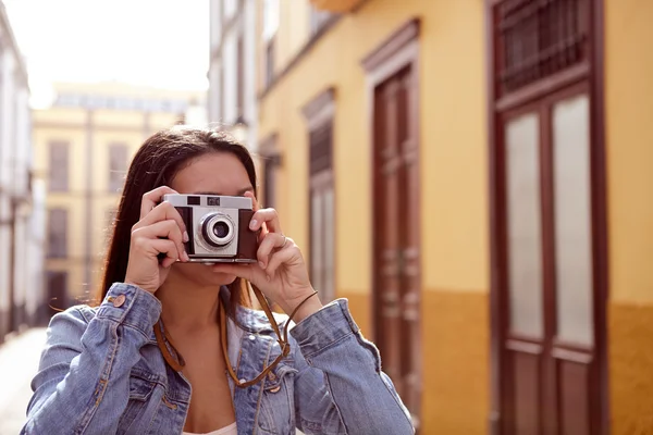 Pretty young girl taking a picture in an alley