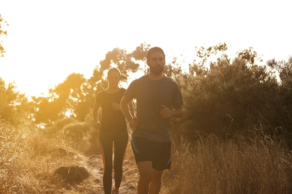 Young couple running in bright sunshine