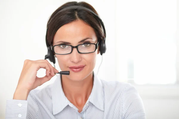 Seductive woman receptionist talking on headset