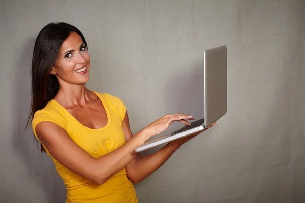 Smiling woman holding laptop