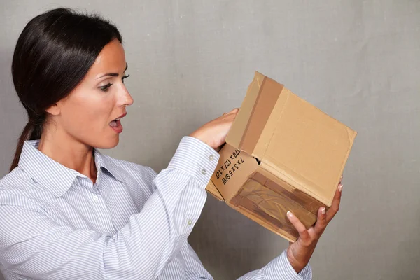 Surprised woman opening box