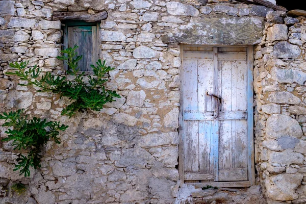 Old wooden door and window in stone wall, vintage style