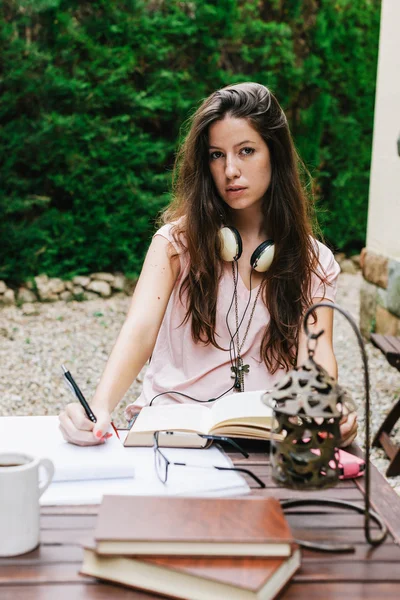 Young beautiful female sitting outside and studying hard.