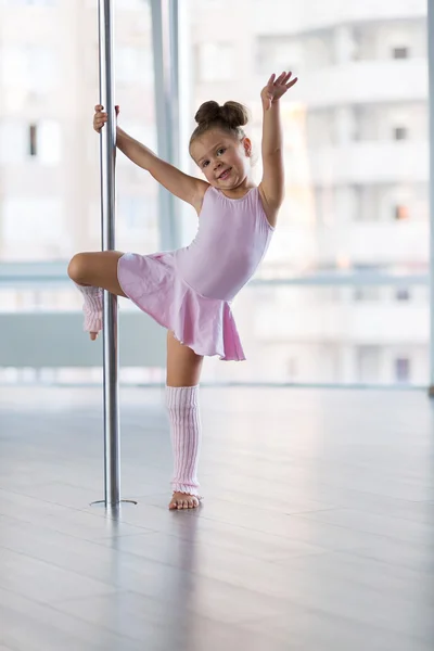 Little dancer in the pole dance studio