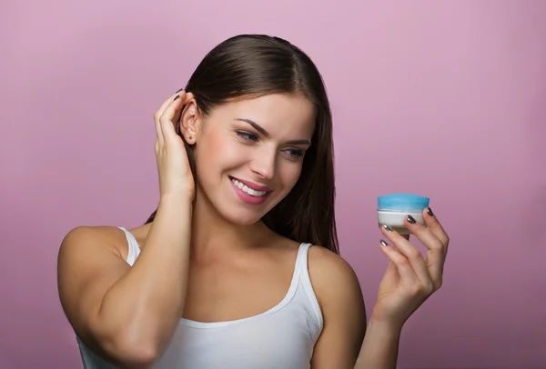 Pretty woman with a skin care product