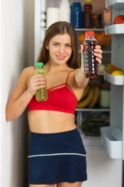 Sporty woman by the fridge