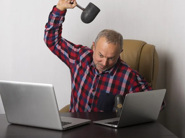 Angry man crashing laptop