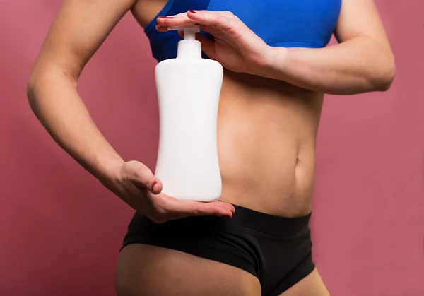 Sporty woman with body lotion