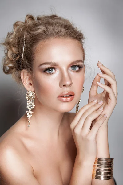 Blond beauty woman portrait with golden hair jewelry and ear-rings