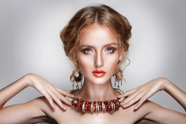Blond hair beauty woman portrait wears golden ear-rings and necklace