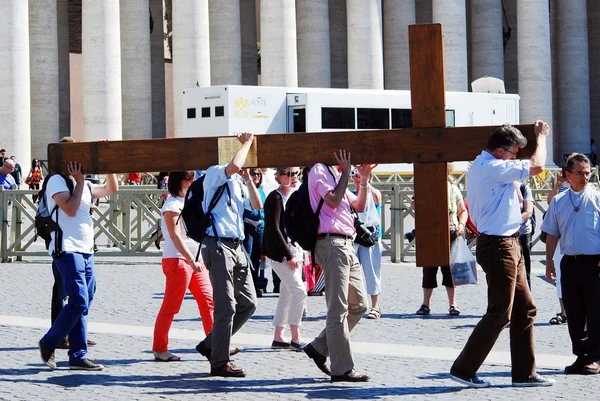 Vatican city center life - pilgrims carry cross