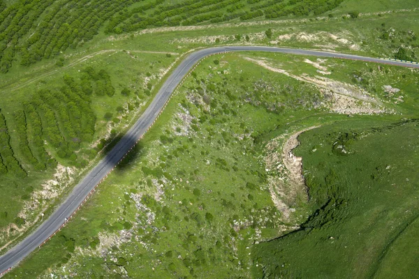 View of the countryside with road from a hot air balloon and it's shadow on the ground, Armenia