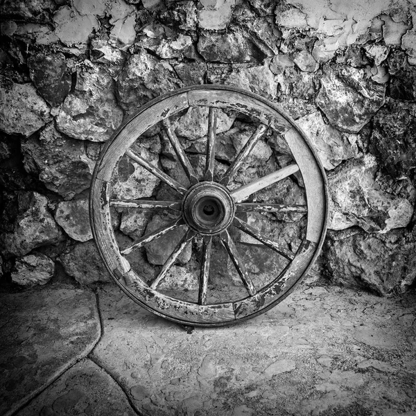 Old Wooden Cart Wheel against Stone Barn, Armenia