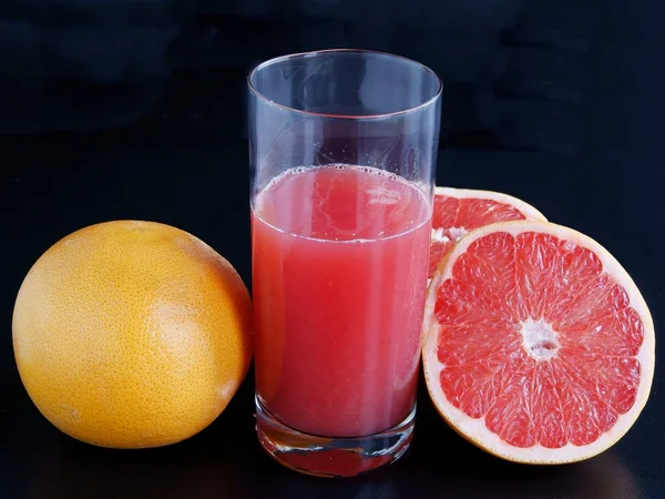 Red grapefruit and juice in glass