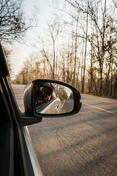 Car mirror and photographer take a photo of inside road
