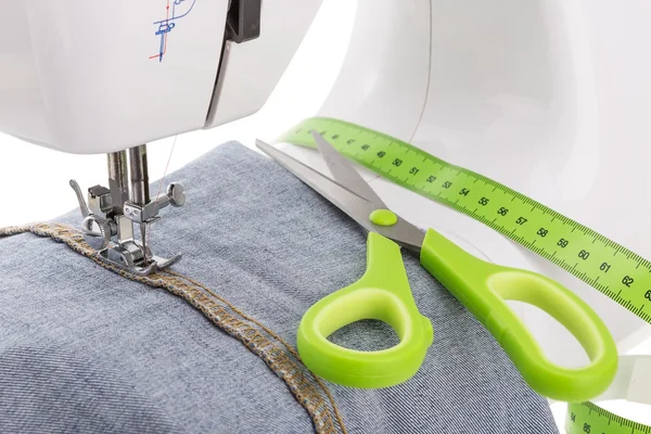 Dressmaker scissors, sewing machine and meter. Textile close-up.