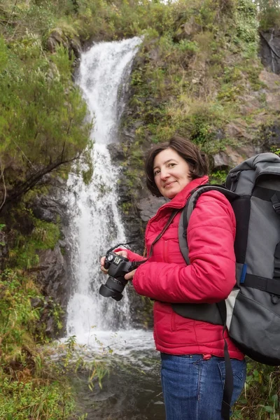 Woman hiker smiling and photographed waterfall. In Portugal, the village Monchique.