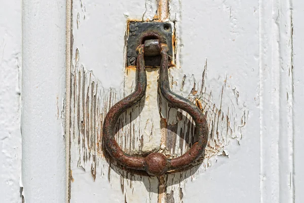 Old vintage door handle. On the white door.