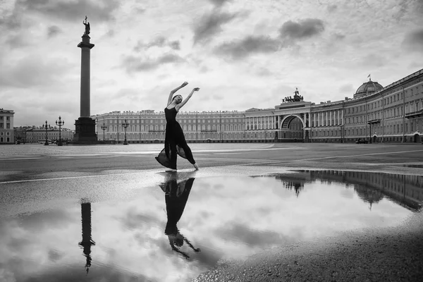 The young woman, the ballerina dances on the square