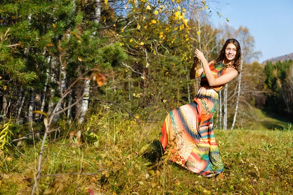 Happy young woman in the autumn wood of the mountain