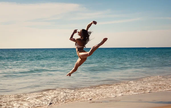 The girl  dances at sunset on the seashore