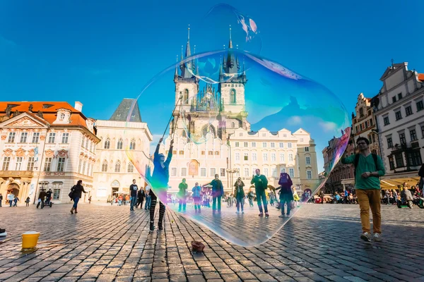 Unidentified young woman makes soap bubbles in Prague