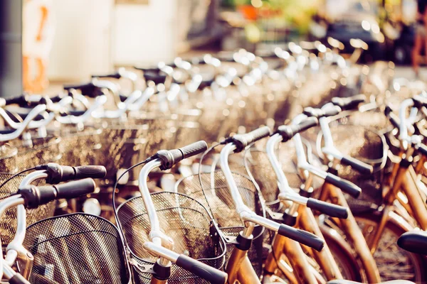 Row Of City Parked Bicycles Bikes For Rent On Sidewalk. Close Up