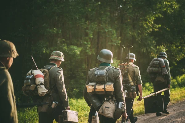 Unidentified reenactors dressed as German soldiers during march in forest