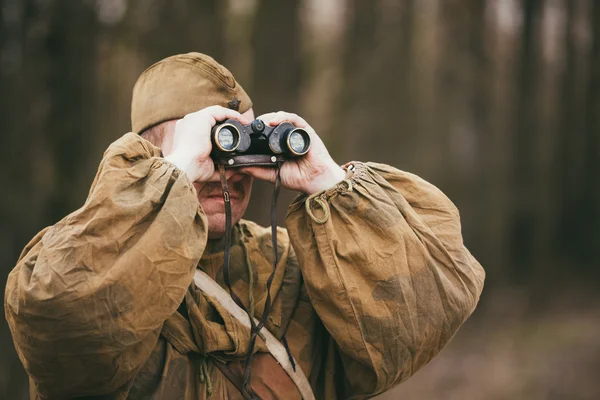 Unidentified re-enactor dressed as Soviet soldier looks at an ar