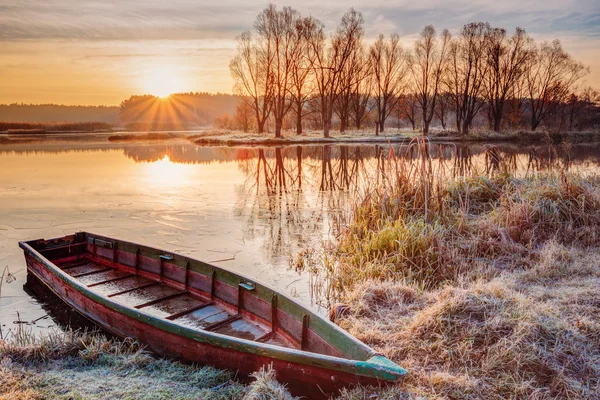 River and rowing fishing boat at beautiful sunrise in autumn morning.