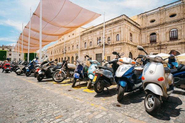 Motorbikes, motorcycles, scooters parked in city.