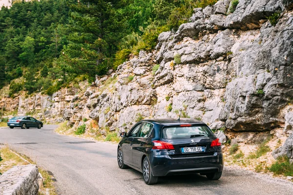 Black colour Peugeot 308 car on background of French mountain na