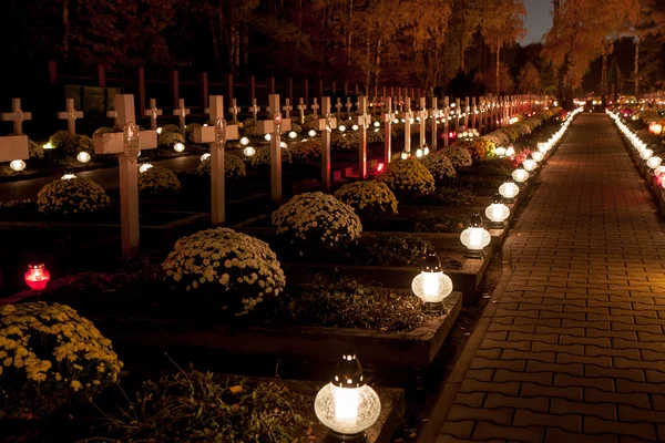 Alley of graves with lighted candles in a Catholic cemetery