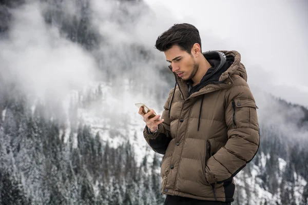 Young man in at mountain using cell phone